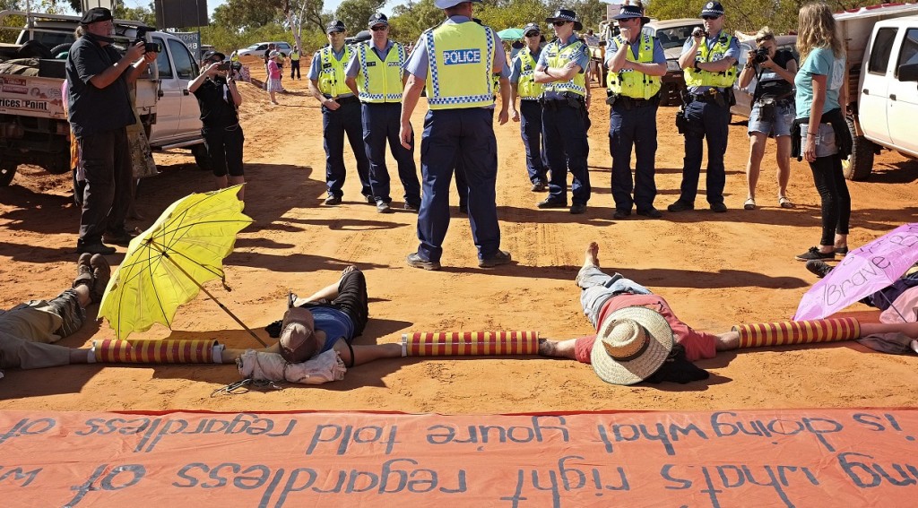 Activists lying down on Manari Road in a blockade direct action 