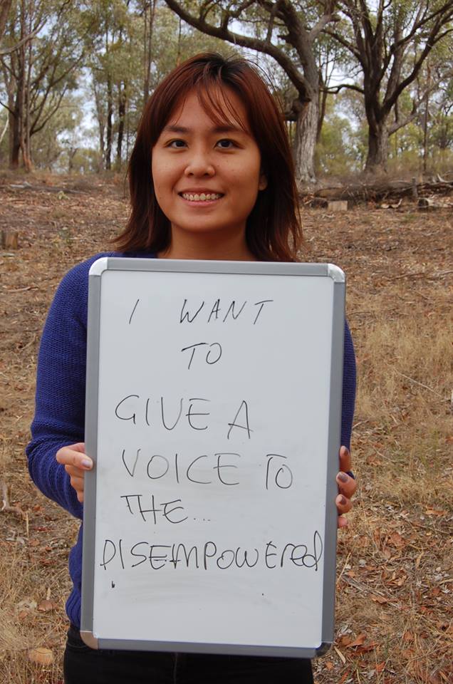 Woman holding a white board with the words "I want to give a voice to the disempowered"