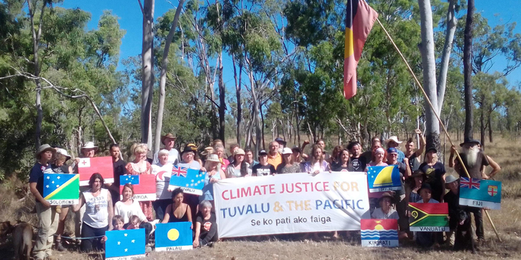 Activists holding a banner reading Climate justice for Tuvalu & the Pacific