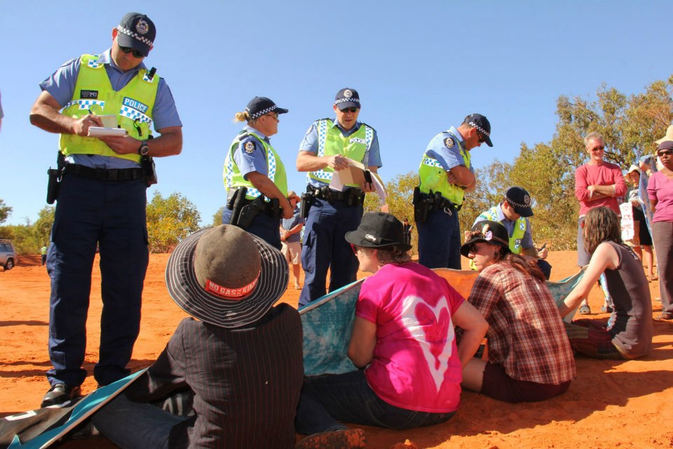 People sitting on a road talking to police; action planning including considering the legal aspects